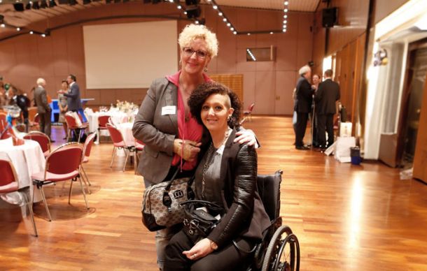 zwei Frauen, eine davon im Rollstuhl, bei der Preisverleihung für die Auszeichnung Lebensspur